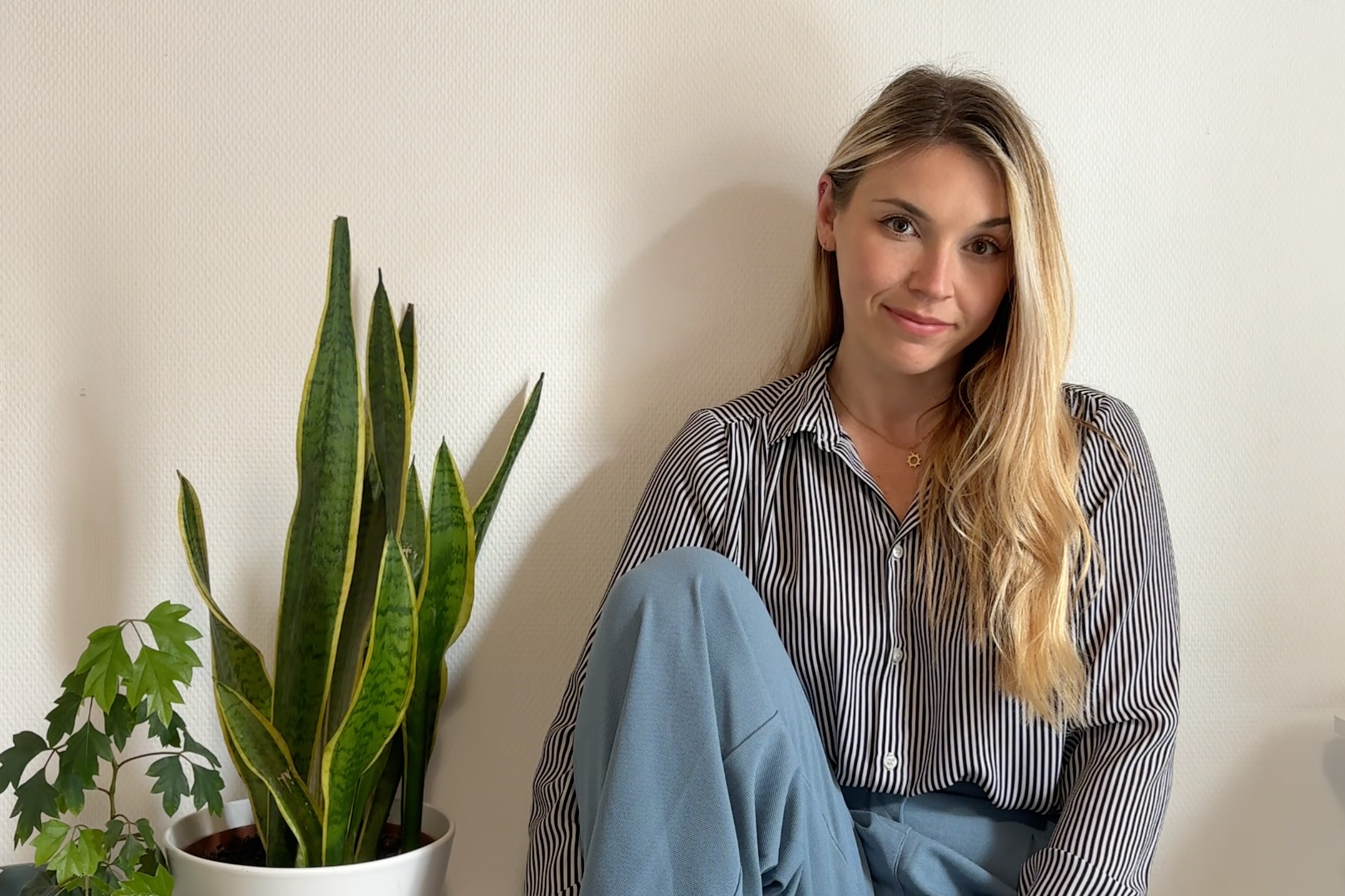 Joanna Slupek looking at the camera next to a plant